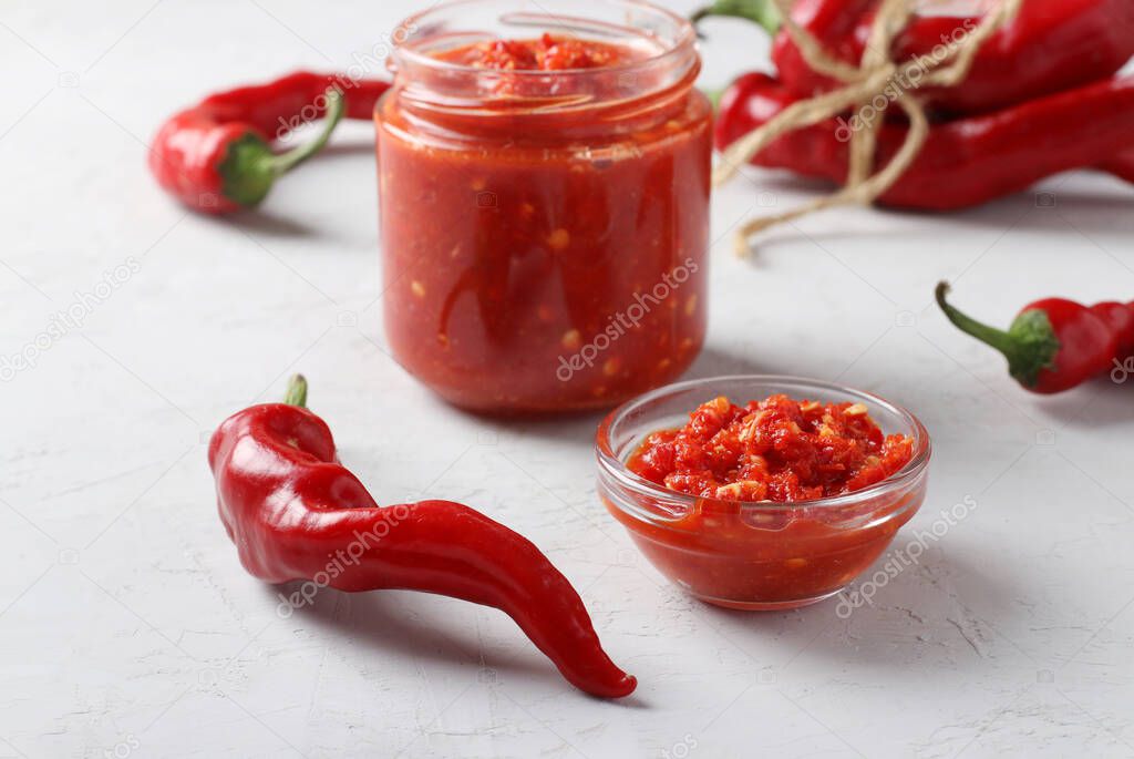 Salsa piccante africana in un vasetto con peperoncini rossi.